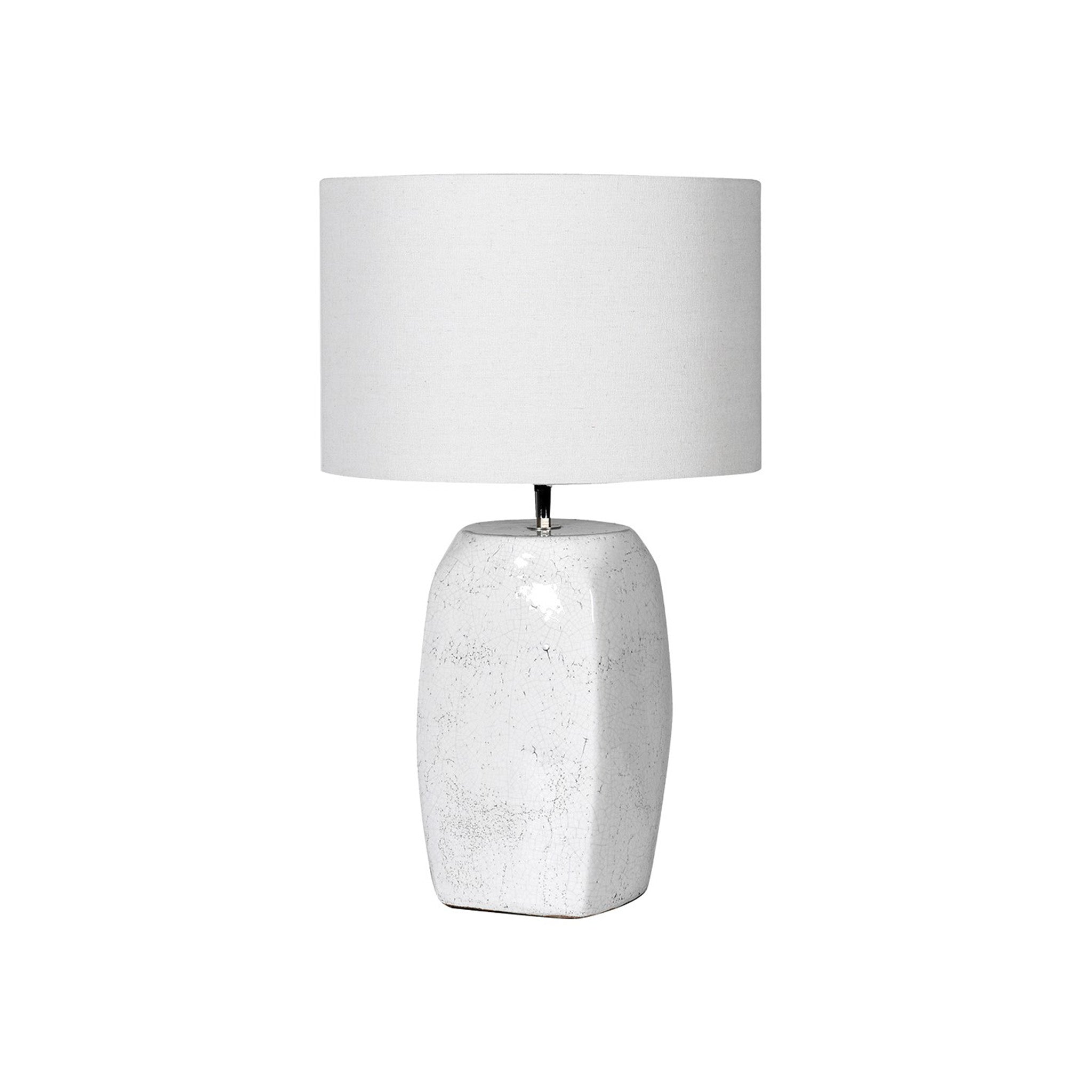 White lamp with an oblong block base, with a crackle finish surface. Supplied with a white linen shade   Dimensions: H:630 Dia:380 mm  Delivery: 7-10 days